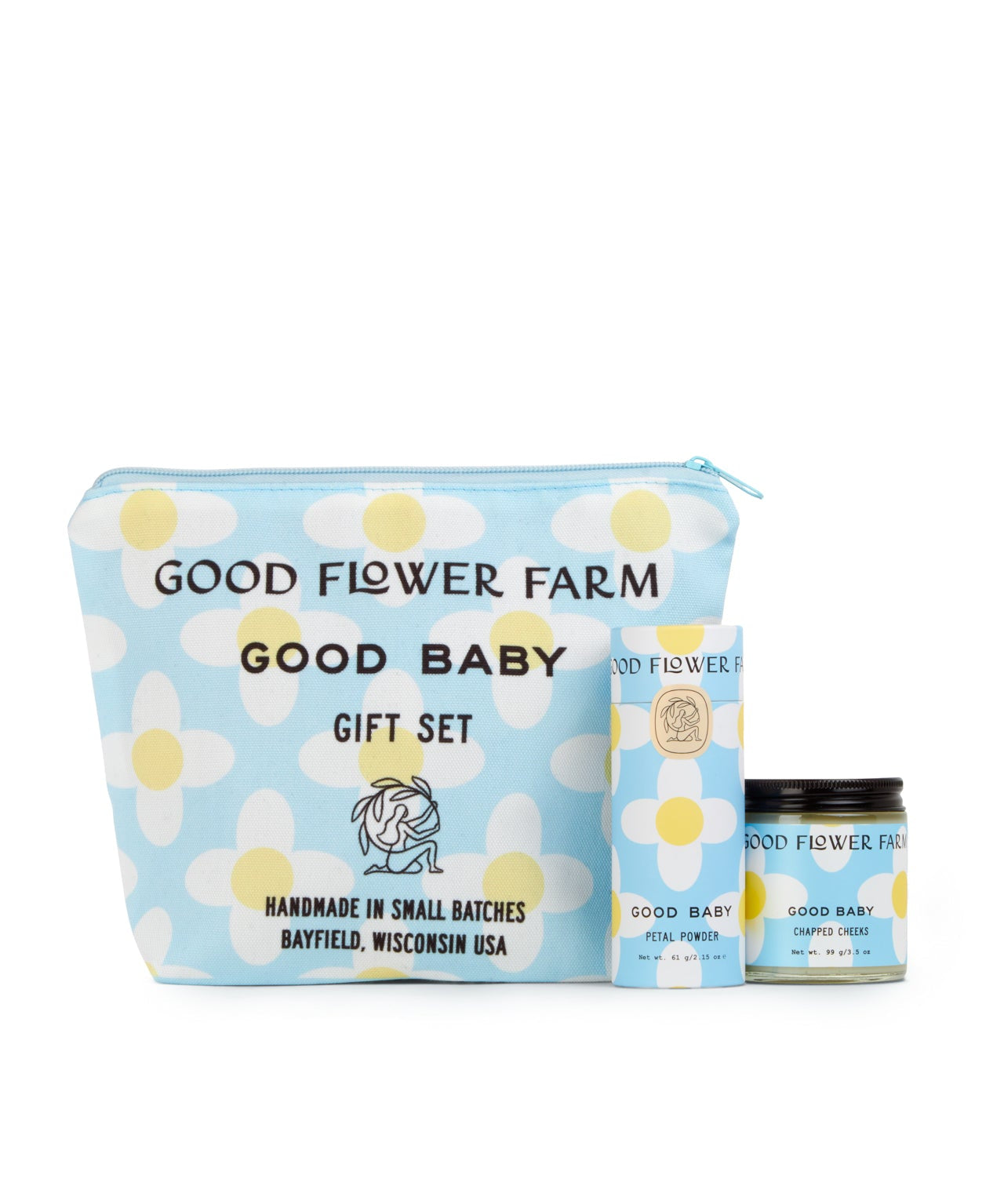 The Good Baby Gift Set by Good Flower Farm includes a blue cosmetic bag with white and yellow floral designs, plus a matching box and jar, featuring baby diaper balm made with gentle botanical ingredients.