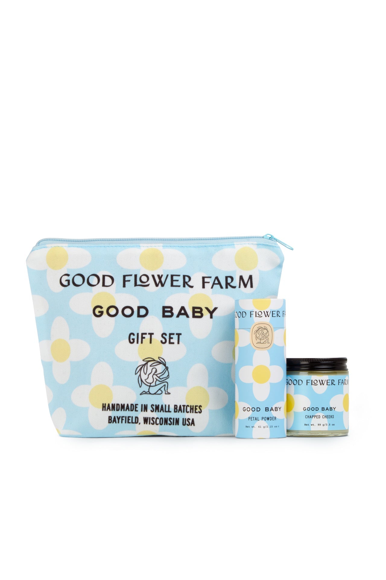 The Good Baby Gift Set by Good Flower Farm includes a blue cosmetic bag with white and yellow floral designs, plus a matching box and jar, featuring baby diaper balm made with gentle botanical ingredients.