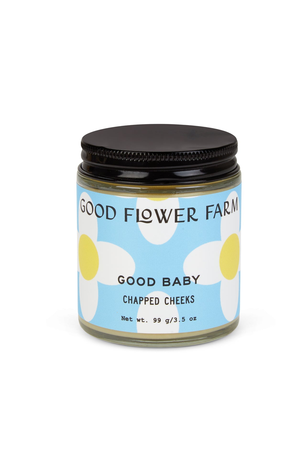 A glass jar from Good Flower Farms Good Baby Gift Set has a blue and white label with white flowers, a black screw-on lid, and is made with gentle botanicals; the jar contains 99g (3.5 oz) of baby diaper balm.